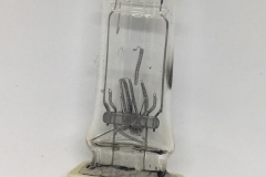 T11 Lamp with filament broken due to being knocked while hot, with burn mark visible on envelope